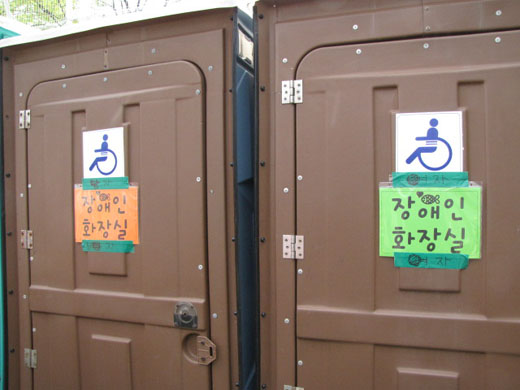 주최 측이 장애인들의 항의로 인해 볼펜으로 이동식장애인화장실 출입문에 성별을 표시해 놨다. ⓒ박종태&#13;&#10;