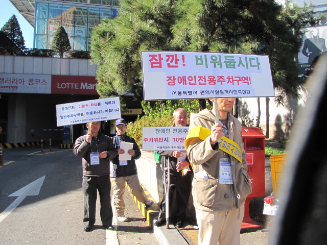 장애인전용주차구역을 비워 두자는 캠페인을 벌이는 장애인들. ⓒ박종태 