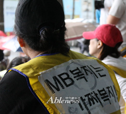 지난 9일 국가인권위원회 앞에서 열린 ‘활동보조서비스 지원 제외 장애인 긴급구제’ 기자회견에 참가 회원의 등 뒤에는 현 정부의 복지정책을 꼬집는 문구가 선명하게 붙어있다. ⓒ에이블뉴스 