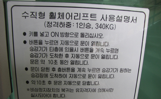 수직형휠체어리프트 안내판에는 탐승 후 손이 불편한 중증장애인이 버튼을 계속 누르면 승강기 도착 후 자동으로 문이 열린다고 설명돼 있다. ⓒ박종태