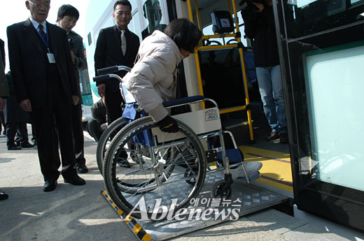 수동휠체어를 타는 염혜숙(39) 씨가 버스 한쪽을 기울여 경사로의 경사를 완만하게 한 후 혼자서 저상버스에 오르고 있다. ⓒ에이블뉴스