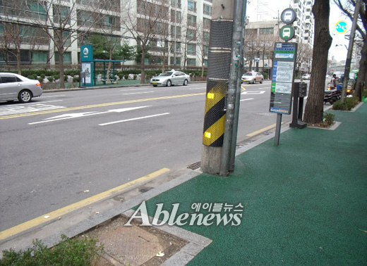 6211번 저상버스가 지나는 용산구 이촌동 점보맨션 정류장. 화단이 정류소 쪽에 너무 가까이 닿아 있고, 가운데 세워진 전봇대가 휠체어 이동을 방해한다. ⓒ에이블뉴스