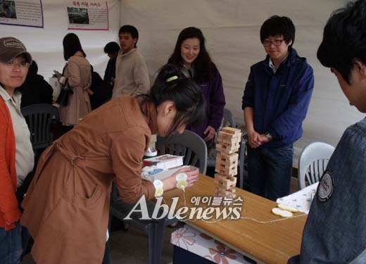 편마디 장애 체험을 해보고 있는 시민들. ⓒ에이블뉴스
