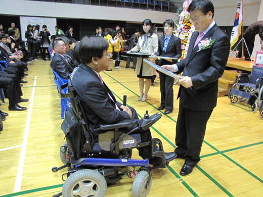 윤성균 안산시 부시장이 단상에서 내려와 장애인 좌석을 찾아와 시상을 하고 있다. ⓒ박종태