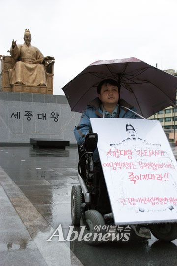 한국장애인자립생활센터협의회 박홍구 회장이 15일 광화문광장 세종대왕 동상 앞에서 '2010년 활동보조서비스 지침개악 철회'를 요구하며 1인 시위를 벌였다. ⓒ에이블뉴스 