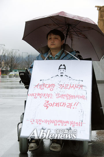 한국장애인자립생활센터협의회 박홍구 회장이 15일 광화문광장 세종대왕 동상 앞에서 '2010년 활동보조서비스 지침개악 철회'를 요구하며 1인 시위를 벌였다. ⓒ에이블뉴스 
