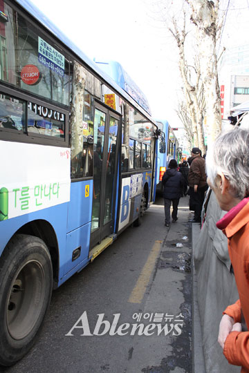 한 할머니가 버스정류장 인도와 멀리 떨어져 정차한 저상버스를 바라보고 있다. 저상버스는 인도 바닥 가까이 정차해야 장애인, 노인, 임산부 등 교통약자가 계단 없이 바로 버스를 탈 수 있어 편리하다. ⓒ에이블뉴스  