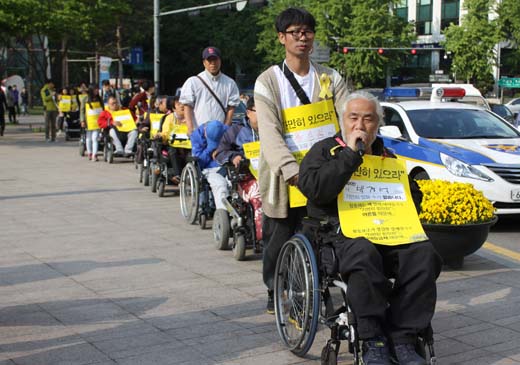 전국장애인차별철폐연대 박경석 공동상임대표가 행렬을 이어나가며 복지부 장관의 공식적인 사과와 대책마련을 촉구하고 있다. ⓒ에이블뉴스